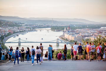 People enjoying great view on Budapest city with Danube river and bridge during the sunset in Hungary. People is out of focus