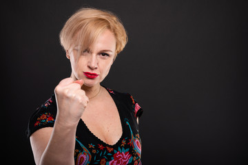 Portrait of cool fashionable woman posing showing fist.