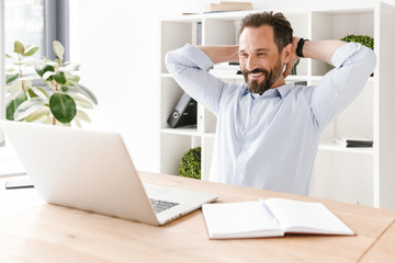 Smiling businessman looking at laptop computer
