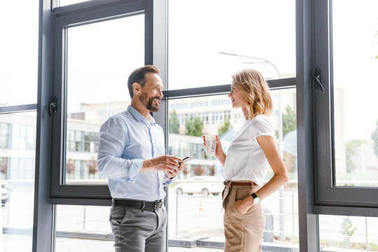 Couple of smiling colleagues talking - Powered by Adobe