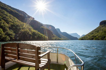 Dam in South Africa seen from deck of pleasure boat with bench in foreground. The Blyde dam.