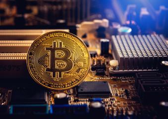 Golden bitcoin cryptocurrency on computer electronic circuit board