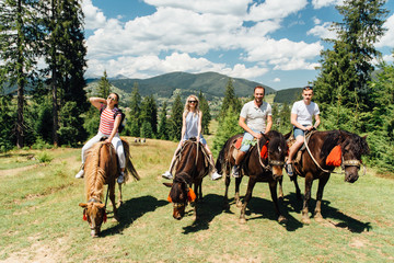 group of people riding horses in the mountains