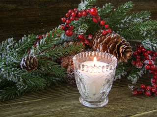 Christmas decorations and a candle on a wooden background