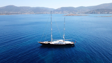 Fototapeta premium Aerial drone bird's eye view photo of wooden deck luxury sail boat docked in mediterreanean deep blue waters