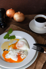 Healthy breakfast, poached eggs and black coffee on wooden table