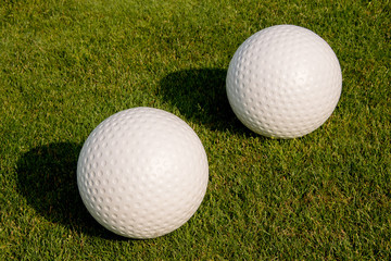 Golfbälle liegen im im kurz geschnittenen Gras vom Golfplatz