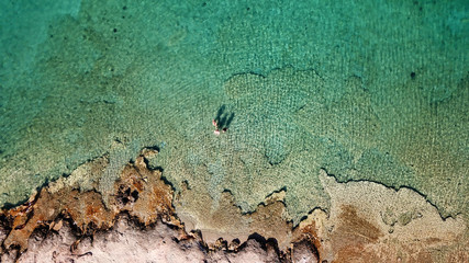 Aerial drone bird's eye view photo from turquoise clear water seascape in island of Shinousa or Schinoussa, Cyclades, Greece
