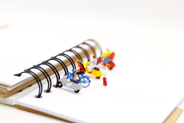 Miniature people parking on the book spine.