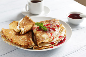 French crepes with jam on a plate close up
