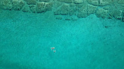 Aerial drone bird's eye view photo from turquoise clear water seascape in island of Shinousa or...