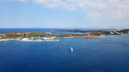 Aerial drone, bird's eye photo from iconic lake Vouliagmeni famous for healing abilities and Ateras Peninsula at the background, Athens riviera, Attica, Greece