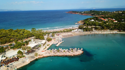 Aerial drone bird's eye photo of famous celebrity wavy sandy beach of Astir or Asteras in south Athens riviera with turquoise clear waters, Vouliagmeni, Greece