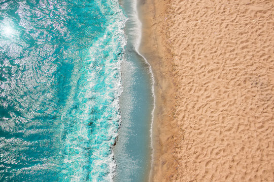 Coastline Beach Ocean waves with foam on the sand. Top view from drone.