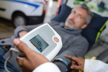 Paramedic taking patient's blood pressure