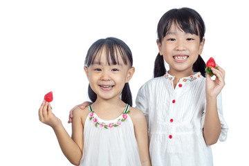 Asian Little Chinese sisters holding Strawberry