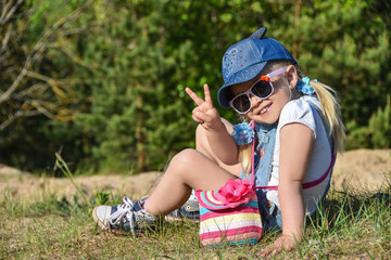 Little girl is playing and laughing on the green lawn in summer