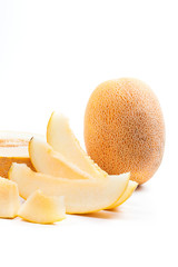 Close up view of whole, half and sliced honeydew melon tropical fruit isolated on a white background.