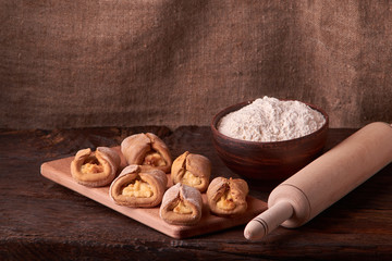 Cottage cheese cookies and little flour on oak wooden background. Macro, close up. Selective focus