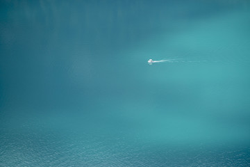 Weisses Motorboot auf türkisfarbenem See