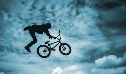 Fototapeta na wymiar Silhouette of a man doing an jump with a bmx bike.
