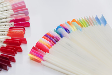 Fan of nail art polish tips samples isolated on white.