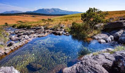 View of rock pools in South Africa with mountains in the background. The Mac Mac pools.