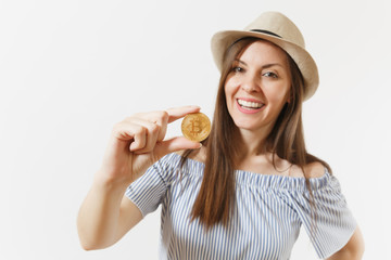 Young elegant woman in blue dress, hat with long hair holding bitcoin, coin of golden color isolated on white background. Finance, business, virtual currency concept. Advertising area. Copy space.