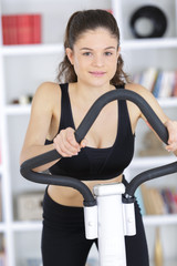 fit brunette working out on exercise bike
