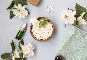 Spa setting flatlay with bath salt ,jasmine flowers and oil bottles