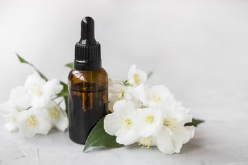 Jasmine essential oil. Bottle of jasmine aromatherapy oil with jasmine flowers