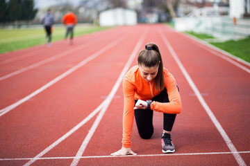 Fototapeta premium Sportowa kobieta patrząc na smartwatch podczas wykonywania ćwiczeń