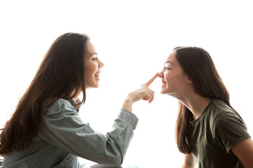 Two sisters playing with each other and having a great time together over white background