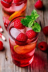 Raspberry Mojito Lemonade with lime and fresh mint in glass on wooden background