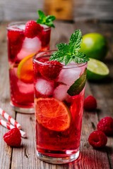 Raspberry Mojito Lemonade with lime and fresh mint in glass on wooden background