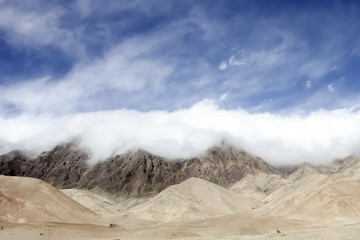 Fototapeta na wymiar extremely low clouds creep across the ridge, Tibet