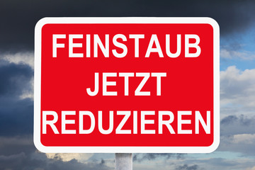 Red and white warning sign with german text FEINSTAUB JETZT REDUZIEREN, meaning reduce fine dust now