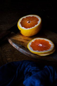 Orange's half and its slices on a wood table