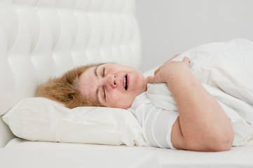 senior woman sleeping and snoring on the bed