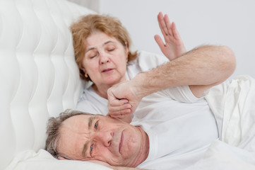 elderly couple is quarreling on the bed