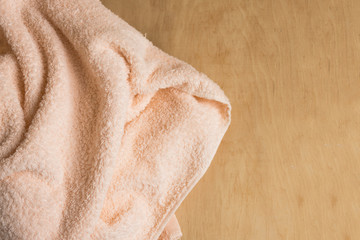 Soft bath towel on wooden background. Copy space. Mockup for design.