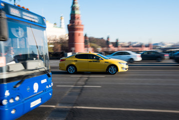 Yellow taxi car in motion on city street