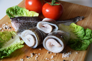 raw fish fillet with tomatoes, spices and onions