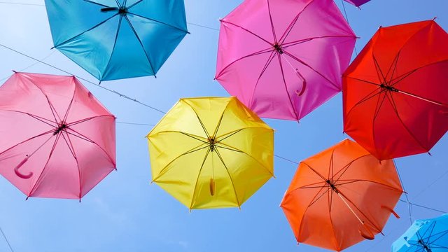 4K Colorful umbrella hanging against cloudy blue sky