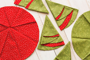 patchwork and sewing concept - macro of decorative red-and-green napkins on whitewashed wooden...