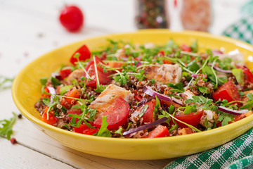 Healthy dinner.  Salad bowl lunch with grilled chicken and quinoa, tomato, sweet peppers, red onions and arugula on white background.
