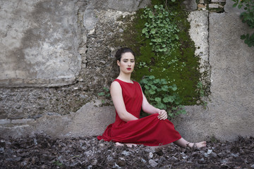 Melancholic girl with red dress in nature