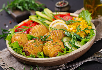 Fototapeta na wymiar Vegetarian buddha bowl. Raw vegetables and baked potatoes in bowl. Vegan meal. Healthy and detox food concept.