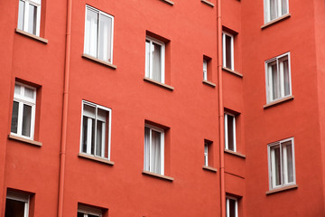 Fototapeta na wymiar Decorative white window on an old red urban wall .