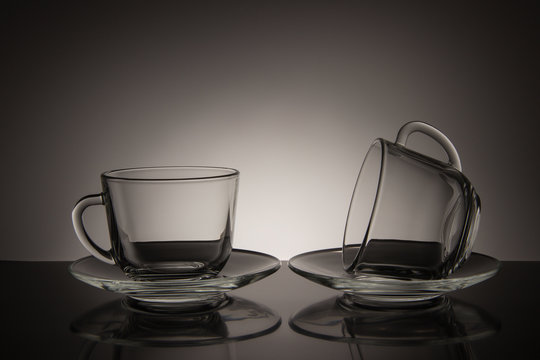 Two glass for tea and an empty saucer on a black and white background